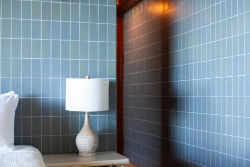 a lamp on a table in a bedroom with blue tiles at Frenchman's Cove Resort in Port Antonio