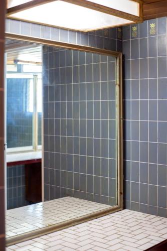 a mirror in a bathroom with blue tiles at Frenchman's Cove Resort in Port Antonio