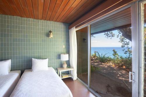 a bedroom with a bed and a view of the ocean at Frenchman's Cove Resort in Port Antonio