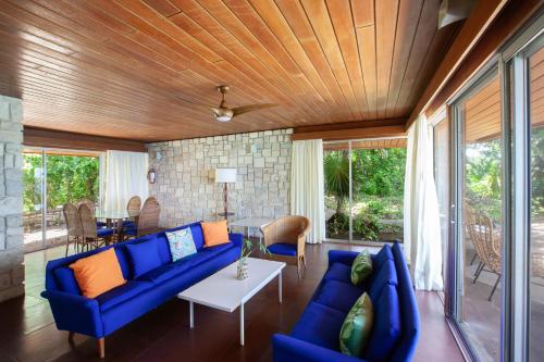 a living room with a blue couch and a table at Frenchman's Cove Resort in Port Antonio