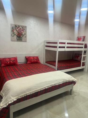 een slaapkamer met 2 stapelbedden met rode kussens bij ChloeHouse in Napels