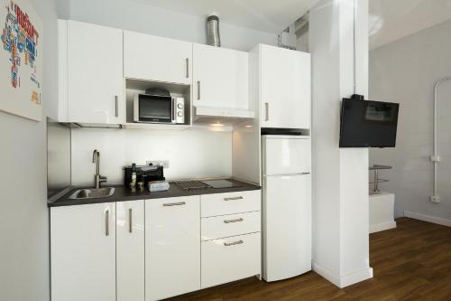 a kitchen with white cabinets and a microwave at Veoapartment Elcano 14 in Seville