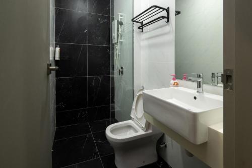 uma casa de banho com um WC branco e um lavatório. em Penang KTHOME Beacon Executives suite em George Town