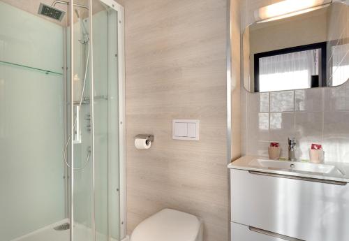uma casa de banho com um chuveiro, um WC e um lavatório. em Hôtel Les Sources em Vernet-les-Bains