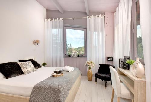 a bedroom with a bed and a desk and a window at Hôtel Les Sources in Vernet-les-Bains