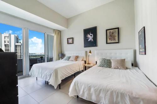 2 camas en un dormitorio con vistas a la ciudad en Splendid Penthouse with Balcony & Free Parking, en Miami Beach