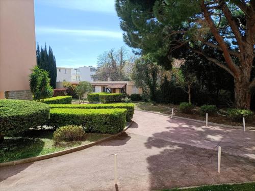 un jardin avec des buissons et des arbres et un bâtiment dans l'établissement T2 à 50 mètres de la mer, à Saint-Cyr-sur-Mer