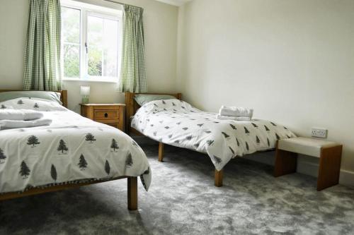 a bedroom with two beds and a window at 3BD Gem in the Heart of Barnetby Le Wold in Barnetby le Wold