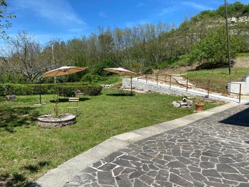 eine Terrasse mit 2 Sonnenschirmen und einem Grasfeld in der Unterkunft Bed&Breakfast La Ginestra in Abbateggio