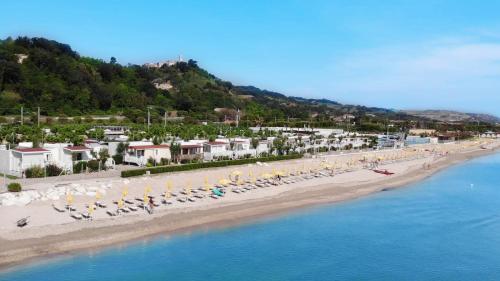an aerial view of a beach with chairs and umbrellas at Girasole Eco Family Village in Marina Palmense