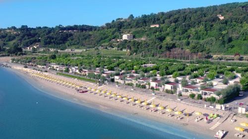 z góry widok na plażę z domkami i parasolami w obiekcie Girasole Eco Family Village w mieście Marina Palmense