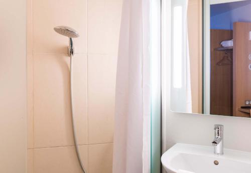 een badkamer met een douchegordijn en een wastafel bij B&B HOTEL Bourges 1 in Bourges