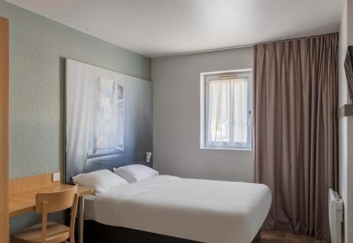 Habitación de hotel con cama y ventana en B&B HOTEL Bourges 1 en Bourges