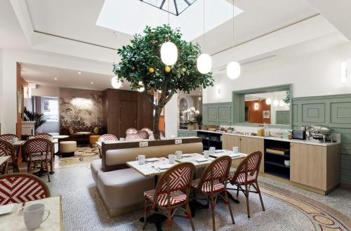 a restaurant with a table and chairs and a kitchen at Timhotel Palais Royal in Paris