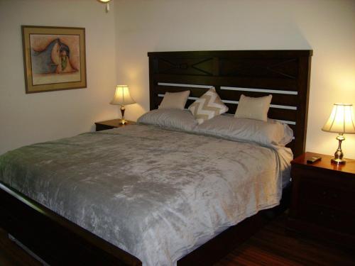 a bedroom with a large bed with two lamps at Oakhaven in Long Beach