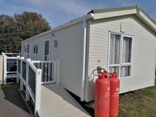 un edificio blanco con dos bocas de incendios rojas al lado en Luxurious Wheelchair-Friendly holiday home at Kent Coast Holiday Park en Allhallows