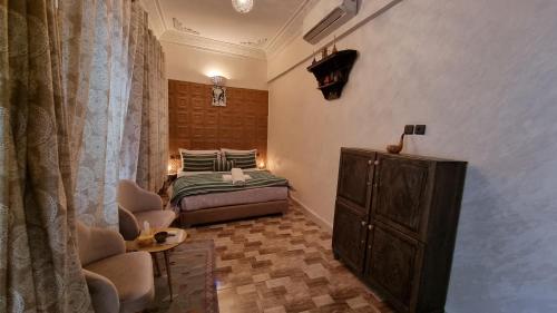 1 dormitorio con cama, silla y vestidor en Riad Fes Touria Palace en Fez