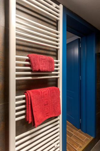 a towel rack in a bathroom with red towels at Kornmarkt Appartments in Bistriţa