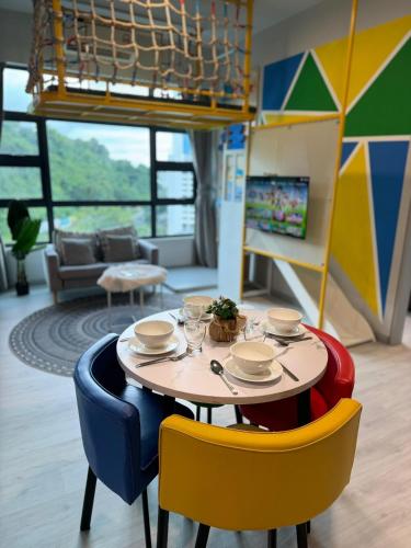 a table and chairs in a room with a couch at JQ#09 City View Slide LoftBed 2R1B 5pax near Suria Mall, Gaya St, SICC in Kota Kinabalu