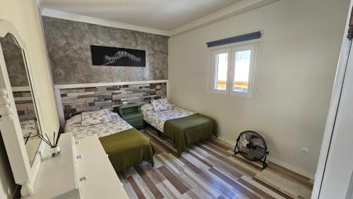 a bedroom with two beds and a window at Apartamentos GARAKOTA in Telde