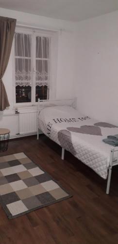 a white bedroom with a bed and a window at CityHome am Markt in Saarbrücken