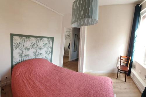 a bedroom with a red bed with a pink blanket at T2 Hypercentre à 200 m de la plage in Villers-sur-Mer