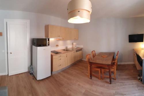 une cuisine avec une table et un réfrigérateur blanc dans l'établissement T2 Hypercentre à 200 m de la plage, à Villers-sur-Mer