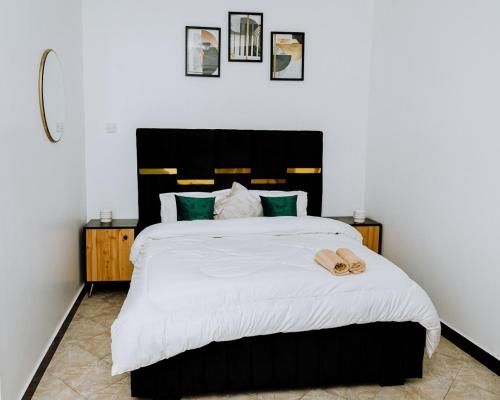 a bedroom with a large bed with a black headboard at LM Apartments in Dar es Salaam