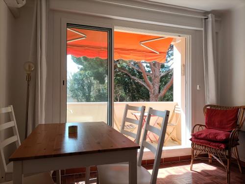 d'une table à manger et de chaises devant une fenêtre. dans l'établissement T2 à 50 mètres de la mer, à Saint-Cyr-sur-Mer