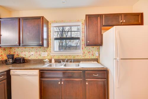 a kitchen with wooden cabinets and a white refrigerator at 4 Mi to HPU Pet-Friendly Home with Yard! in High Point