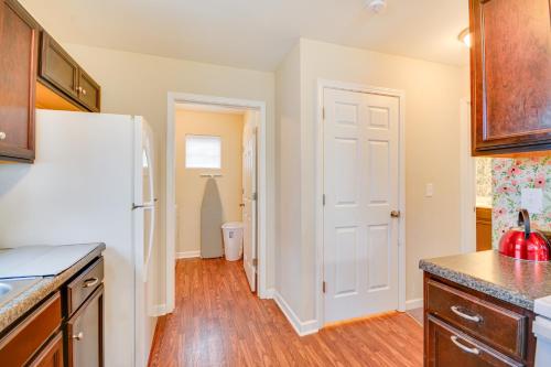 a kitchen with a white refrigerator and wooden floors at 4 Mi to HPU Pet-Friendly Home with Yard! in High Point