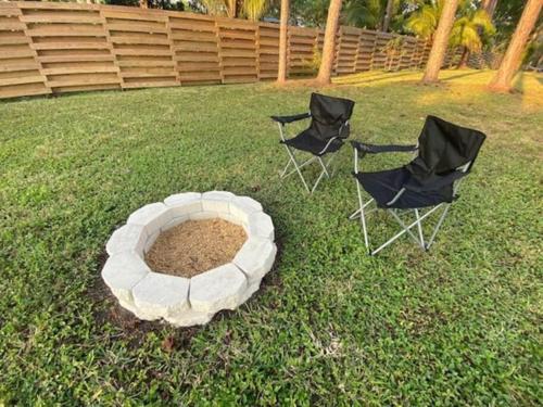 two chairs and a fire pit in a yard at Summer Tiny House in West Palm Beach