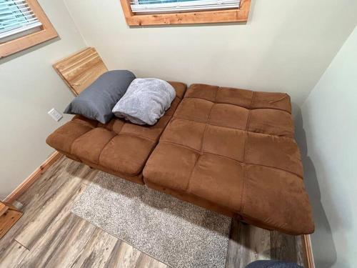 a brown couch with two pillows on it in a room at Summer Tiny House in West Palm Beach