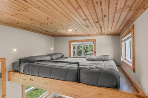a bed in a tiny house with a wooden ceiling at Summer Tiny House in West Palm Beach