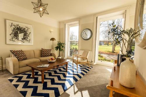 uma sala de estar com um sofá e uma mesa em 24 Montpellier Spa Road em Cheltenham