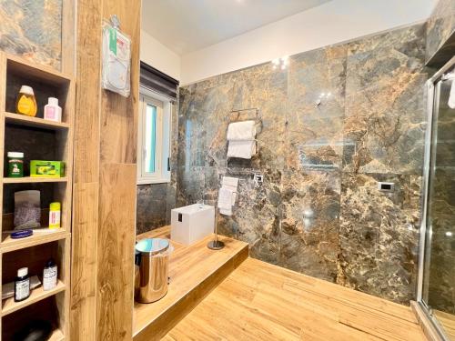 een badkamer met een douche en een glazen deur bij Carrubba's luxury home in San Giovanni la Punta