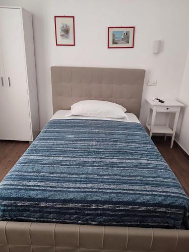 un letto in una camera da letto con una coperta blu sopra di ALO ALO ALBERGO a Casteggio