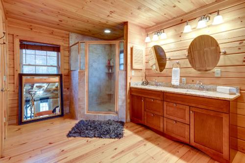 uma casa de banho com um chuveiro e um lavatório. em Riverfront Blue Ridge Cabin with Private Hot Tub em Mill Spring