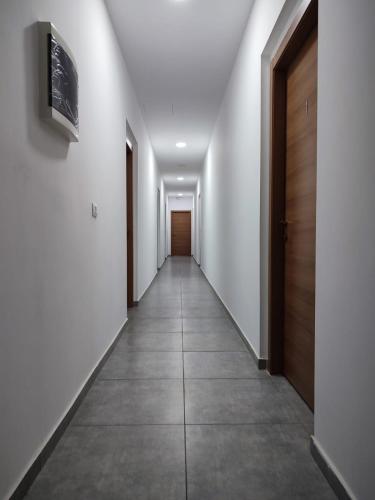 a hallway with white walls and a wooden door at ALO ALO ALBERGO in Casteggio