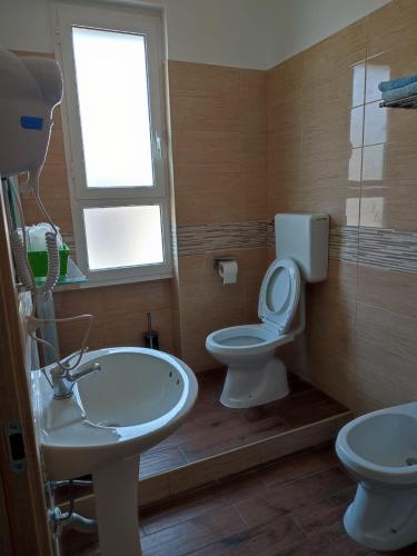 uma casa de banho com um lavatório, um WC e uma janela. em ALO ALO ALBERGO em Casteggio