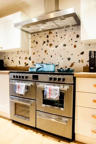 a kitchen with a stainless steel stove top oven at Cotswolds-Stroud-Comfy 4 bed house-Sleeps 10-Free Parking-Wifi in Ebley