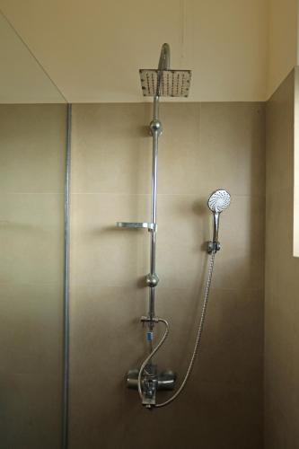 a shower in a bathroom with a shower head at D Plus Resort Negombo in Negombo