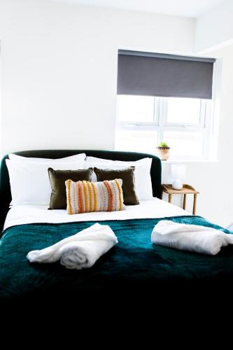 a large bed with two pillows on top of it at Cotswolds-Stroud-Comfy 4 bed house-Sleeps 10-Free Parking-Wifi in Ebley