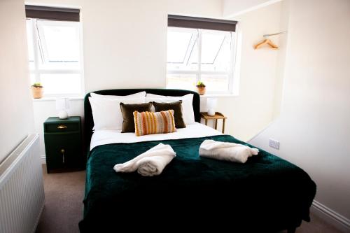 sypialnia z łóżkiem z dwoma ręcznikami w obiekcie Cotswold's Large 4 bed house-Sleeps 10-Free Parking-Wifi 