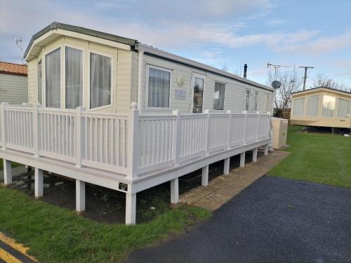 a mobile home with a white fence around it at White Haven - with 2 double rooms in Winchelsea