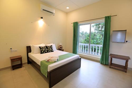 a bedroom with a bed and a large window at D Plus Resort Negombo in Negombo