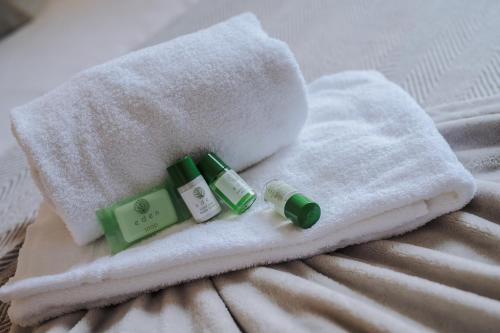 a pile of towels on a bed with two bottles of soap at Pass the Keys Luxury 2 Apt in West Didsbury in Manchester