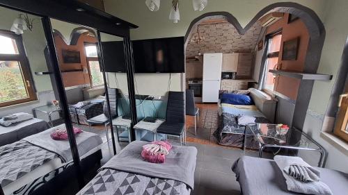 Habitación con varias camas en una habitación con espejos. en Sárkány Lak Budapestnél en Budapest