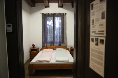 a small bedroom with a bed with a window at Déjá Vu Szállás & Rendezvény Zirc in Zirc