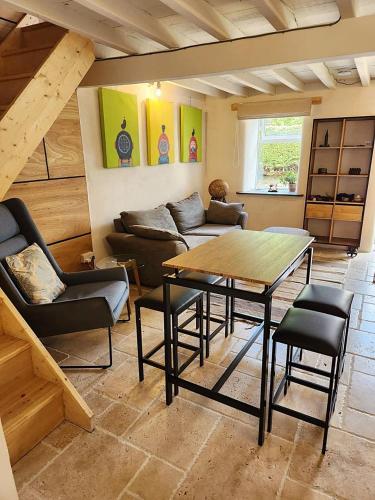 a living room with a couch and a table and chairs at Y Bwthyn Bach Cute Stone Cottage in Tywyn in Tywyn